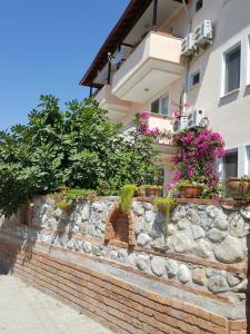 a building with flowers on a brick wall at Karya Apartments in Koycegiz