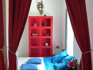 a bedroom with red curtains and a red cabinet at Holidays in Paris Loft design & atypique avec jardin in Massy