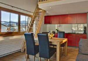kuchnia z drewnianym stołem z krzesłami i drabiną w obiekcie Apartment Alpina w mieście Breil/Brigels