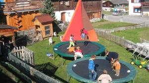 a group of children playing on a trampoline at Apartment Alpina in Brigels