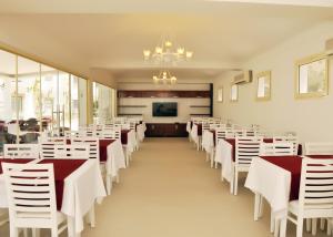 a dining room with white tables and white chairs at Siesta Beach Apartment in Gümbet