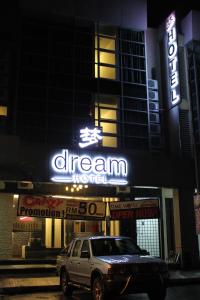 un coche aparcado delante de un teatro por la noche en Dream Hotel, en Klang