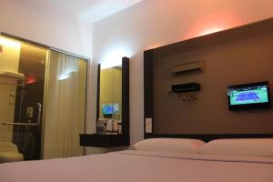 a bedroom with a bed and a tv on the wall at Dream Hotel in Klang +10 photos