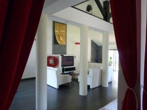 a living room with white furniture and a red curtain at Holidays in Paris Loft design & atypique avec jardin in Massy