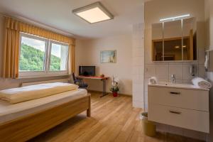 1 dormitorio con cama, lavabo y escritorio en Pension Margarethe en Biedenkopf