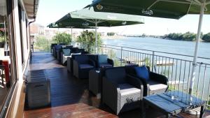 szereg krzeseł i parasol na balkonie w obiekcie B&B Posejdon w mieście Sremska Mitrovica