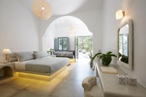 een slaapkamer met een bed en een woonkamer bij Amara Suites Santorini in Kamari +37 foto's