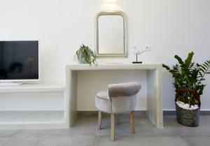a chair sitting under a counter with a mirror at Amara Suites Santorini in Kamari