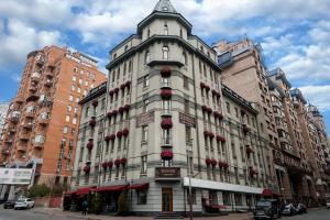 un edificio blanco alto con flores rojas. en Senator Victory Square, en Kiev