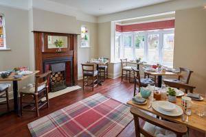 a dining room with tables and a fireplace at Lyndhurst House in Lyndhurst