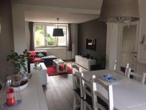 a kitchen and living room with a table and chairs at La Petite Villa in Spa