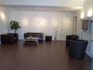 ein Wohnzimmer mit einem Sofa, 2 Stühlen und einem Tisch in der Unterkunft Das Neue Hotel Am Park in Fröndenberg