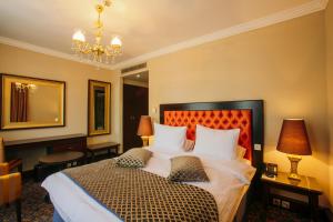 a bedroom with a large bed and a chandelier at Hotel Intourist Palace Batumi in Batumi