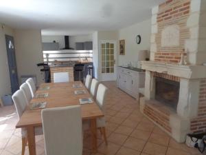 une cuisine avec une table en bois et une cheminée dans l'établissement Villa des Oléandres, à Floure