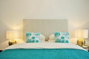 a bedroom with a bed with blue and white pillows at Feeling Eduardo VII in Lisbon