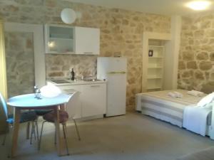 a kitchen and a bedroom with a bed and a table at Apartment Vidačak in Tisno