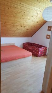 1 dormitorio con 2 camas y techo de madera en Apartman Nóra II., en Bük