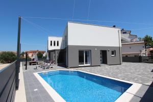 a house with a swimming pool in front of a house at Apartment Karlo 2 in Rovinj