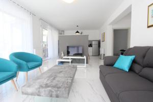 a living room with a couch and chairs and a tv at Apartment Karlo 2 in Rovinj
