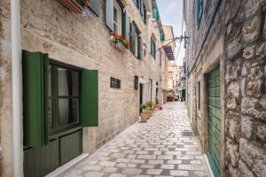 an alley in an old town with green shutters at Fenice Palace in Šibenik