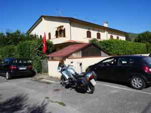 Pugnanoにあるla casa di sandraの建物前の駐車場に駐輪するオートバイ
