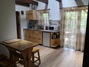 a small kitchen with a table and a microwave at Casa Gozna in Văliug