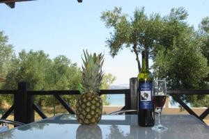 a pineapple and a bottle of wine on a table at Petra's garden in Kraj