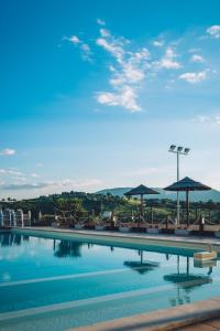 una grande piscina con sedie e ombrelloni di Agriturismo AgrileisureTime a Spoleto