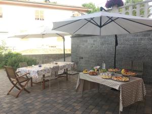 Twee tafels en een paraplu met eten erop. bij Agriturismo La Ferriera in Pignone