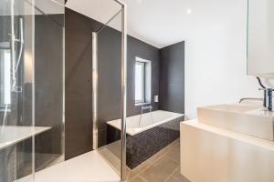 La salle de bains est pourvue d'une douche et d'un lavabo. dans l'établissement Smartflats - Toison d'Or, à Bruxelles