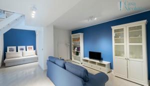 uma sala de estar azul com um sofá e uma televisão em Casa Nicoletta em Noci