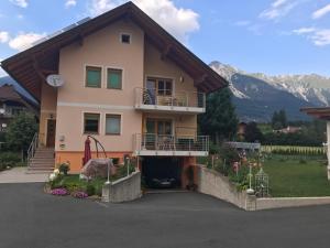 a house with a balcony and mountains in the background at Ferienwohnung Mujcic in Hermagor