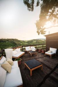 een groep banken en tafels op een houten terras bij Agriturismo AgrileisureTime in Spoleto