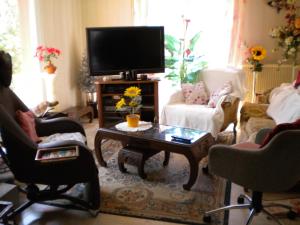 ein Wohnzimmer mit einem TV und einem Couchtisch in der Unterkunft Kerbelle Maria in Port-Louis