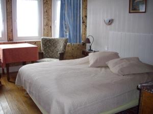 um quarto com uma cama, uma mesa e uma cadeira em Hôtel Des Vosges em Lutzelbourg