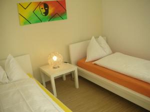 Habitación con 2 camas y mesa con lámpara. en Chasa Glüna, en Ftan