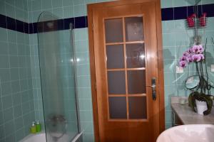 a bathroom with a shower and a glass door at Caloura Camellia House in Caloura +20 photos