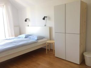 a bedroom with a bed and a white cabinet at Guest House Vitaja in Bled