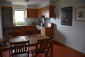 a kitchen with a wooden table and chairs and a dining room at Caloura Camellia House in Caloura