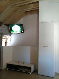 a living room with a tv on the wall at Apartment Vidačak in Tisno