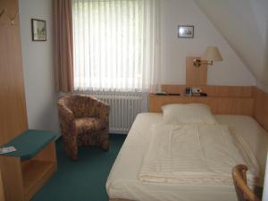 Habitación de hotel con cama y silla en Hotel Ohrberg en Hameln
