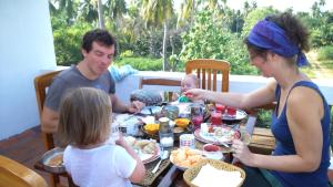 a group of people sitting at a table eating food at Tranquility Guest House in Srīrangam