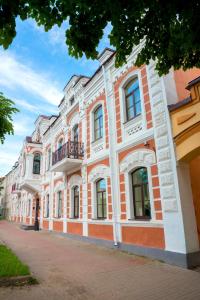 a large orange and white building on a street at Rachmaninoff Hotel in Velikiy Novgorod