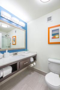 een badkamer met een toilet en een grote spiegel bij Holiday Inn Express Saint Simons Island, an IHG Hotel in Saint Simons Island