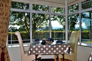 a dining room with a table and chairs and a window at Annaswood B&B & Tours in Cahir