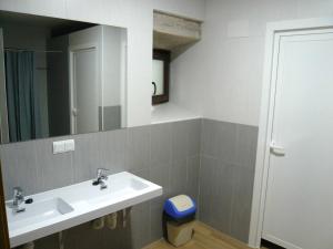 a bathroom with a sink and a mirror at Albergue El Paso in Vega de Valcarce