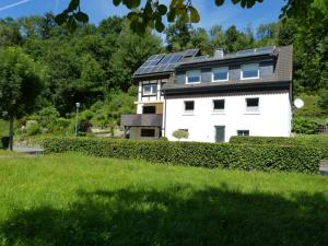 une maison blanche avec des panneaux solaires sur son toit dans l'établissement Ferienwohnung rundumgruen, à Olpe
