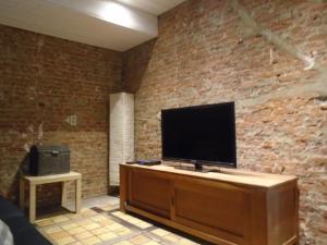 ein Wohnzimmer mit einem TV an einer Backsteinwand in der Unterkunft Apartment Meylhof in Kontich