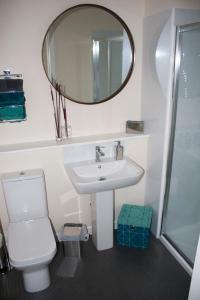 uma casa de banho com um lavatório e um espelho em Lexington Apartments em Rothesay