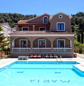 a house with a swimming pool in front of a house at Maria Apartments in Sidari